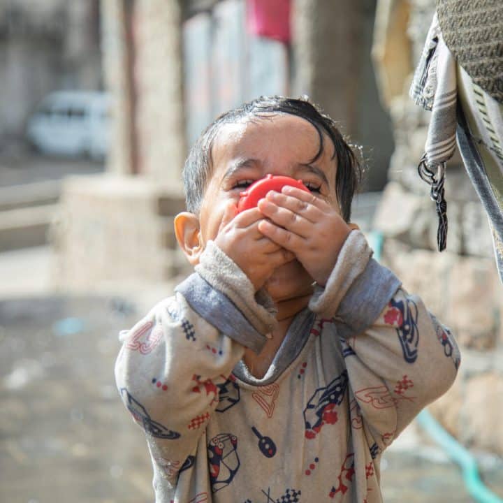 Le petit Rayan , âgé de 2 ans et demi, dans le quartier d'Al Nusayria - district d'Al Mudhaffar - gouvernorat de Taizz, est heureux de boire de l'eau et de célébrer l'arrivée de l'eau dans son quartier. © UNICEF/UN0610688/Al-Basha