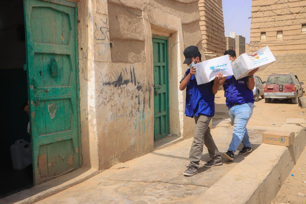 Des travailleurs humanitaires transportent des kits humanitaires pour les personnes déplacées à l'intérieur du pays à Marib, au Yémen. Le 29 mars 2022. © UNICEF/UN0630393/Al-Nahari