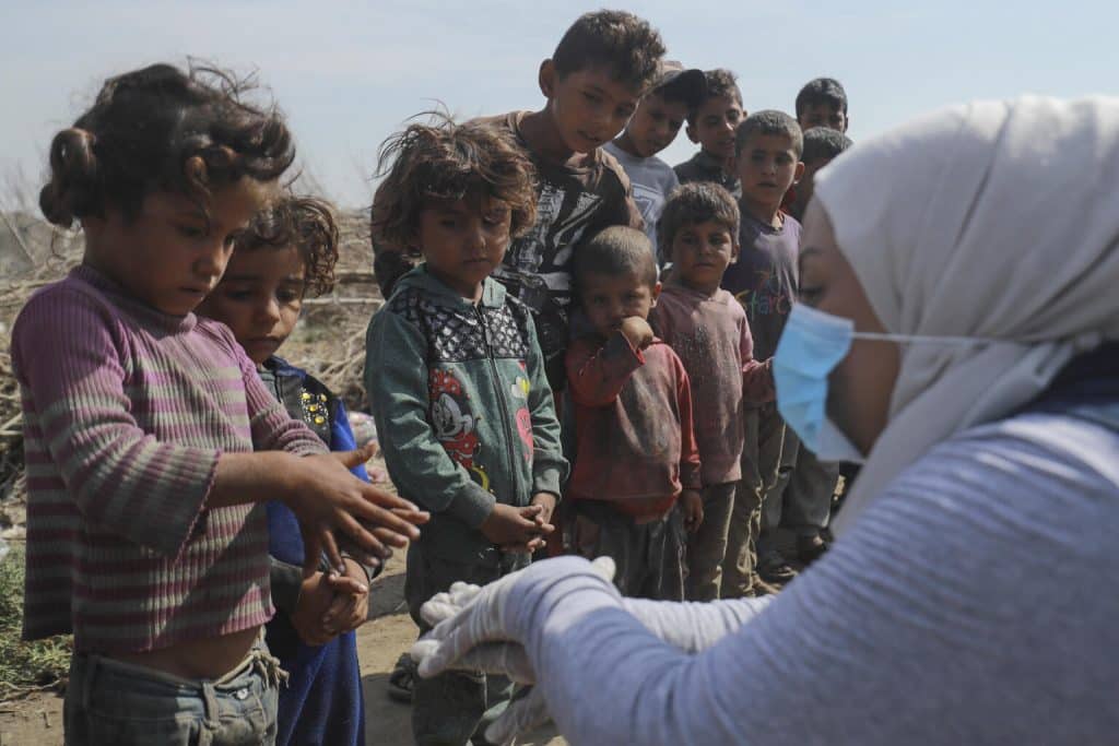 Des bénévoles, soutenus par l'UNICEF, sensibilisent les enfants à l'importance de l'hygiène personnelle et aux moyens de prévenir la propagation du choléra dans le quartier informel de Yawnani, à Raqqa, dans le nord-est de la Syrie, le 21 septembre 2022. ©UNICEF/UN0710328/Souleiman