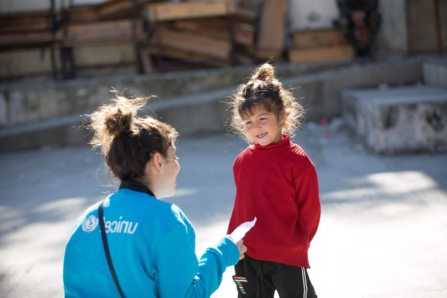 Le 20 février 2023, Naya, une fillette de quatre ans, montre son dessin à un membre du personnel de l'UNICEF lors d'une activité artistique dans un abri du village de Stamo, en Syrie. Naya a fui sa maison à cause du tremblement de terre et utilise le dessin pour exprimer ses émotions. ©UNICEF/UN0792084/Haddad