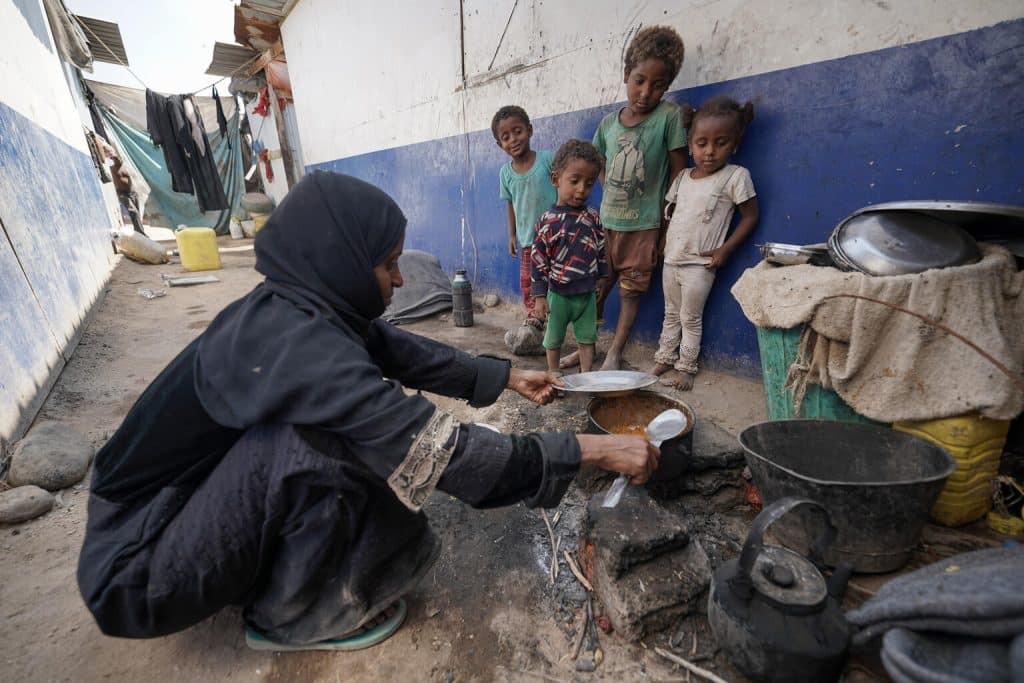 Le 9 février 2023 au Yémen, Fatima Muhammed Saeed, 35 ans, prépare un repas sous le regard de ses enfants. © UNICEF/UN0793381/Bin Hayan - YPN