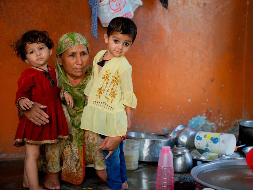 Le 22 novembre 2022 à Karachi, au Pakistan, Halima est assise avec ses petites-filles, Ayd, 18 mois (à gauche) et Iman, 4 ans (à droite), après qu'elles ont été vaccinées contre la polio. © UNICEF/UN0756301/Bukhari