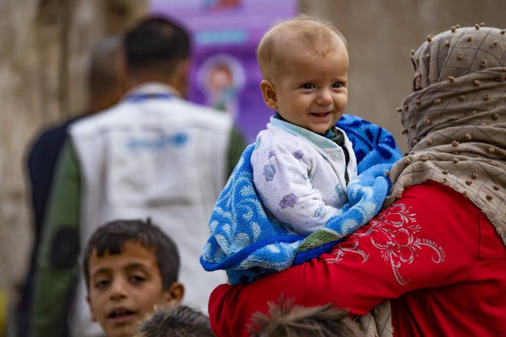 Rawda tient Ariam, 6 mois, en attendant son tour pour vacciner son fils par une équipe mobile du ministère de la Santé dans le quartier de Ghwairan, ville de Hasakeh, nord-est de la Syrie, le 26 octobre 2022. © UNICEF/UN0757751/Souleiman