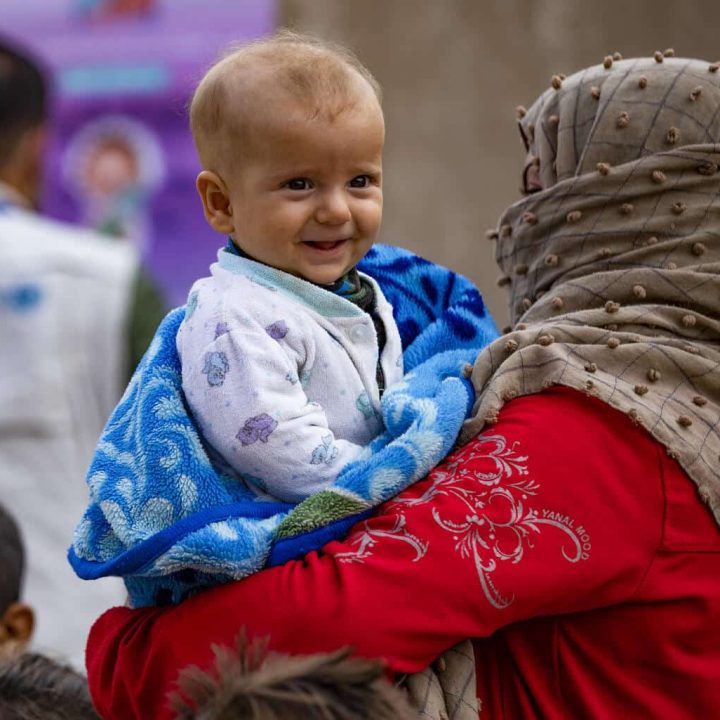 Rawda tient Ariam, 6 mois, en attendant son tour pour vacciner son fils par une équipe mobile du ministère de la Santé dans le quartier de Ghwairan, ville de Hasakeh, nord-est de la Syrie, le 26 octobre 2022. © UNICEF/UN0757751/Souleiman