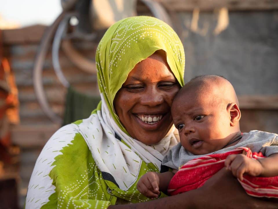 Le 29 octobre 2022 au Puntland, en Somalie, Nasro Dire, une mère, tient son fils d'un mois, Marwan Abdi, dans leur maison du camp de Jawle pour les personnes déplacées à l'intérieur du pays à Garowe. © UNICEF/UN0758490/Ekpu VII Photo