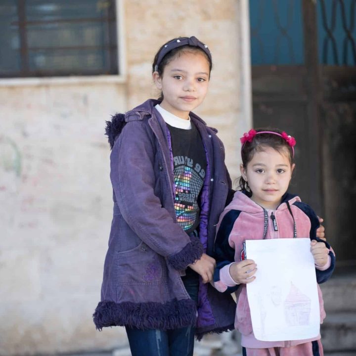 Le 20 février 2023, Maysaa, 13 ans, et sa sœur Renad, 6 ans, se tiennent devant leur abri du village de Stamo, situé dans le gouvernorat de Lattaquié en Syrie. ©UNICEF/UN0792079/Haddad