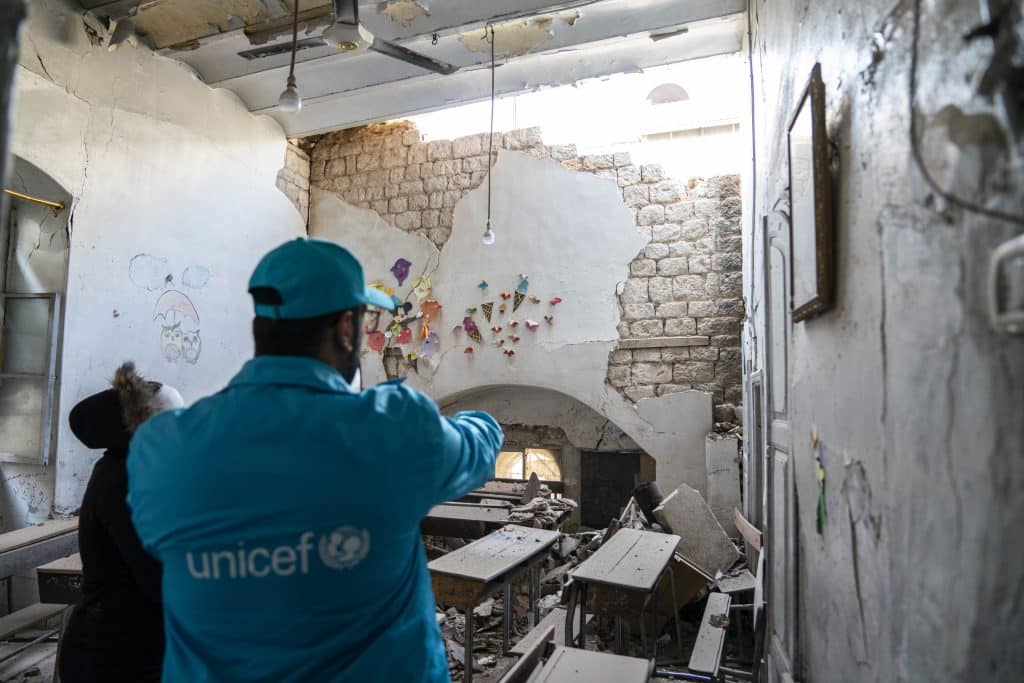 Le 12 février 2023, dans la ville d'Alep, en Syrie, un membre du personnel de l'UNICEF examine les dégâts causés par le récent tremblement de terre à l'école Almahabbeh, dans le quartier d'Alazizyieh, aux côtés de la directrice de l'école, Maysa. © UNICEF/UN0782269/Al-Asadi