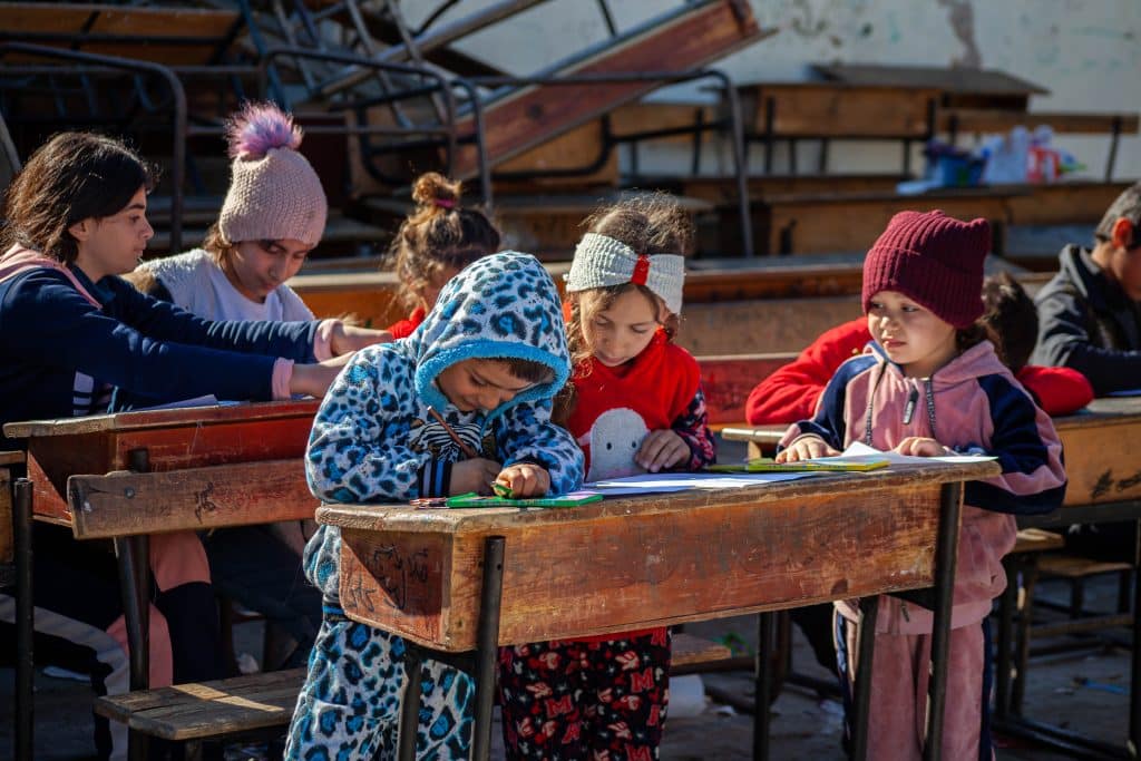 Des enfants déplacés participent à des activités récréatives proposées par des bénévoles soutenus par l'UNICEF dans un abri collectif de la région rurale de Lattaquié, au nord-ouest de la Syrie, le 20 février 2023. Plus d'une centaine de personnes se sont réfugiées dans cet abri après les tremblements de terre dévastateurs qui ont frappé la Syrie le 6 février 2023.© UNICEF/UN0801169/Issa