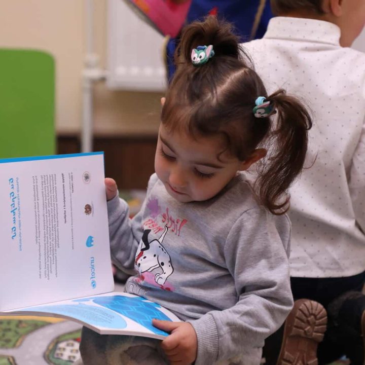 Une petite fille lit un livre dans le nouveau centre d'éducation préscolaire mis en place par l'UNICEF Arménie, le 21 décembre 2022. © UNICEF/UN0766924/Martirosyan