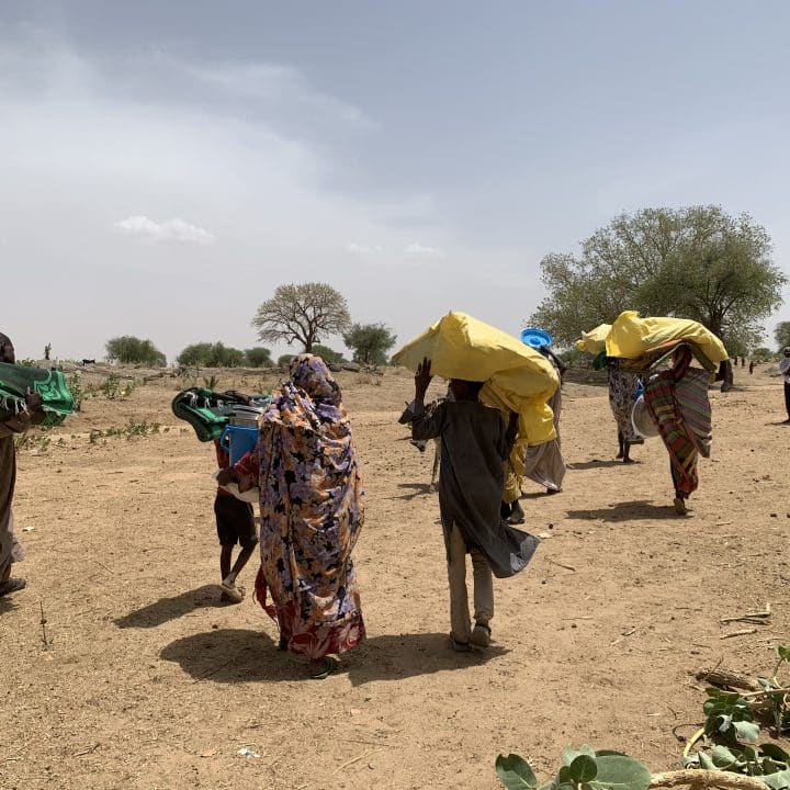 Le 28 avril 2023, des réfugiés soudanais transportent leurs effets personnels alors qu'ils entrent à Koufroun, un village tchadien situé près de la frontière soudanaise. ©UNICEF/UN0834908/Le Du