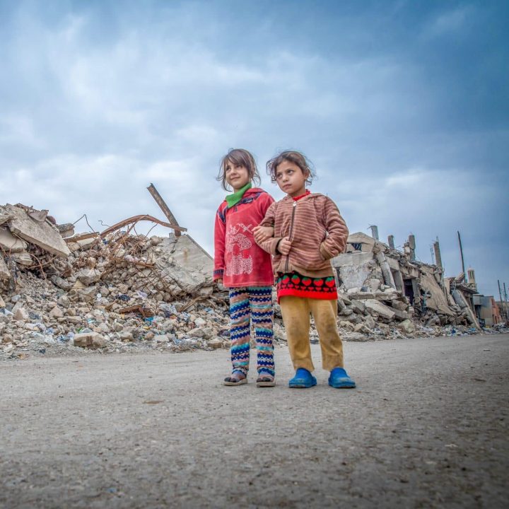 Noor et Sarah marchent dans l'ouest de Mossoul, en Irak, où de nombreux bâtiments ont été totalement détruits. © UNICEF/UN0161148/Anmar