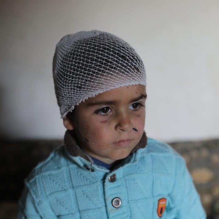 Le 16 février 2023, Musa, six ans, se tient dans le salon détruit de la maison de sa famille à Jandairis, en Syrie. Un mur s'est effondré sur lui lors du tremblement de terre dévastateur, le laissant blessé et obligeant sa famille à fuir et à se réfugier dans une tente de fortune à proximité.