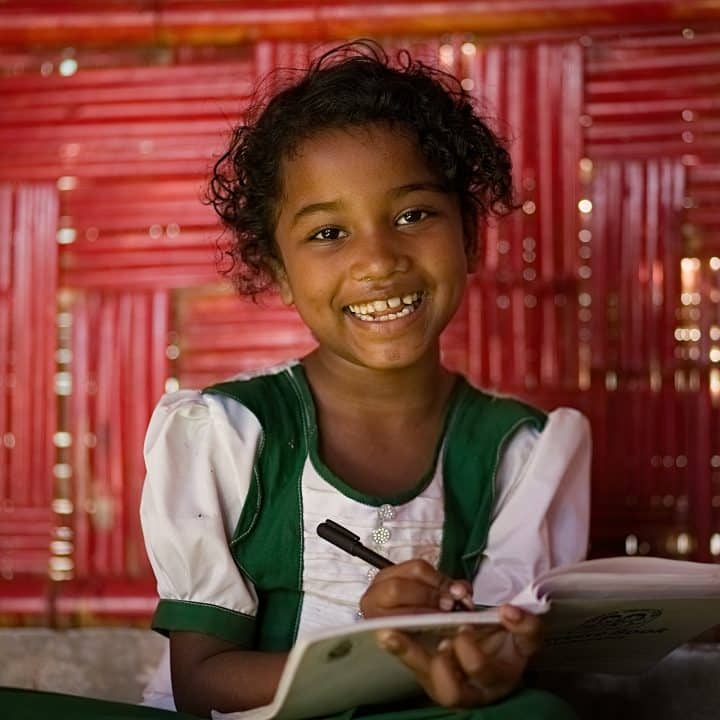 Jonaba, une fillette Rohingya de sept ans, apprend et écrit sur son cahier d'exercices à l'intérieur du Centre d'apprentissage pour enfants de Pahartali. ©UNICEF/UNI416387/Sujan
