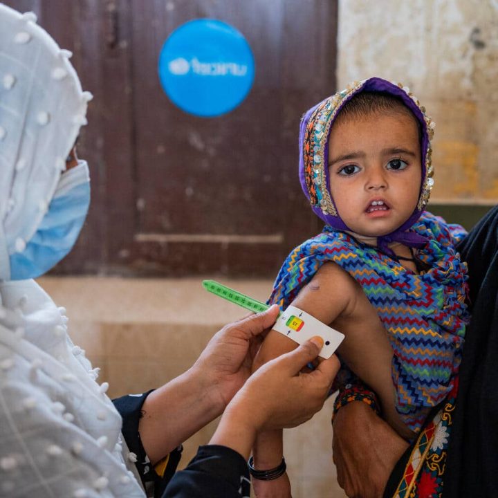 Asiya, assistante nutritionnelle, examine une fillette de 2 ans, pour déterminer son état nutritionnel,