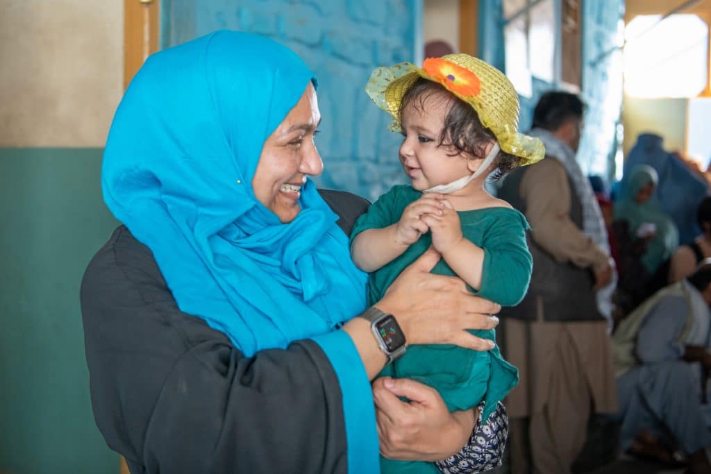 Le 26 juin 2023, Fouzia Shafique, conseillère principale en santé de l'UNICEF Afghanistan, interagit avec une petite fille dans un hôpital soutenu par l'UNICEF dans la province de Kunar, en Afghanistan. © UNICEF/UNI404855/Karimi