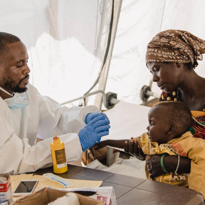 Une mère et son enfant sont reçus en consultation au Centre de traitement du choléra soutenu par l'UNICEF à Bulengo, un site pour les personnes déplacées dans la province du Nord-Kivu, en RDC. UNICEF/UNI407908/Benekire