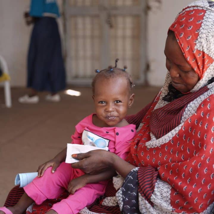 Mona, 16 mois, grignote des aliments thérapeutiques prêts à l'emploi au centre de santé Al-Dabbaghah, dans l'État de Gezira