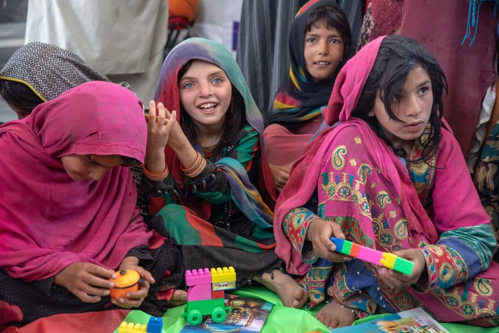 Naghma joue avec les enfants dans un espace soutenu par l'UNICEF Naghma court vers l'espace ami des enfants soutenu par l'UNICEF dans son village en Afghanistan. © UNICEF/UN0697230/Bidel