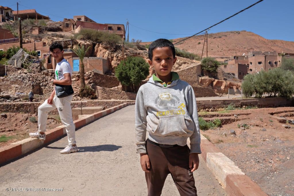 Le 10 septembre 2023, Marwan, 9 ans, se tient devant son village, Azro, près de Tahanaout dans les montagnes de l'Atlas au Maroc, qui a été détruit par un important tremblement de terre. © UNICEF/UNI434147/Benkirane