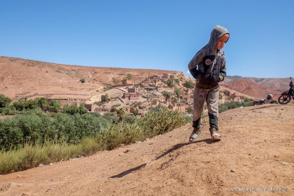 Le 10 septembre 2023, un jeune garçon se tient debout, devant son village, Azro, près de Tahanaout dans les montagnes de l'Atlas au Maroc, qui a été détruit par un important tremblement de terre. © UNICEF/UNI434149/Benkirane