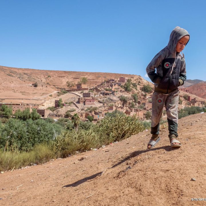 Le 10 septembre 2023, un jeune garçon se tient debout, devant son village, Azro, près de Tahanaout dans les montagnes de l'Atlas au Maroc, qui a été détruit par un important tremblement de terre. © UNICEF/UNI434149/Benkirane