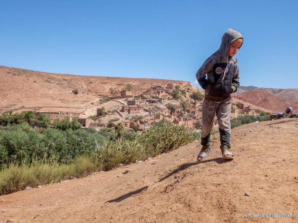 Le 10 septembre 2023, un jeune garçon se tient debout, devant son village, Azro, près de Tahanaout dans les montagnes de l'Atlas au Maroc, qui a été détruit par un important tremblement de terre. © UNICEF/UNI434149/Benkirane