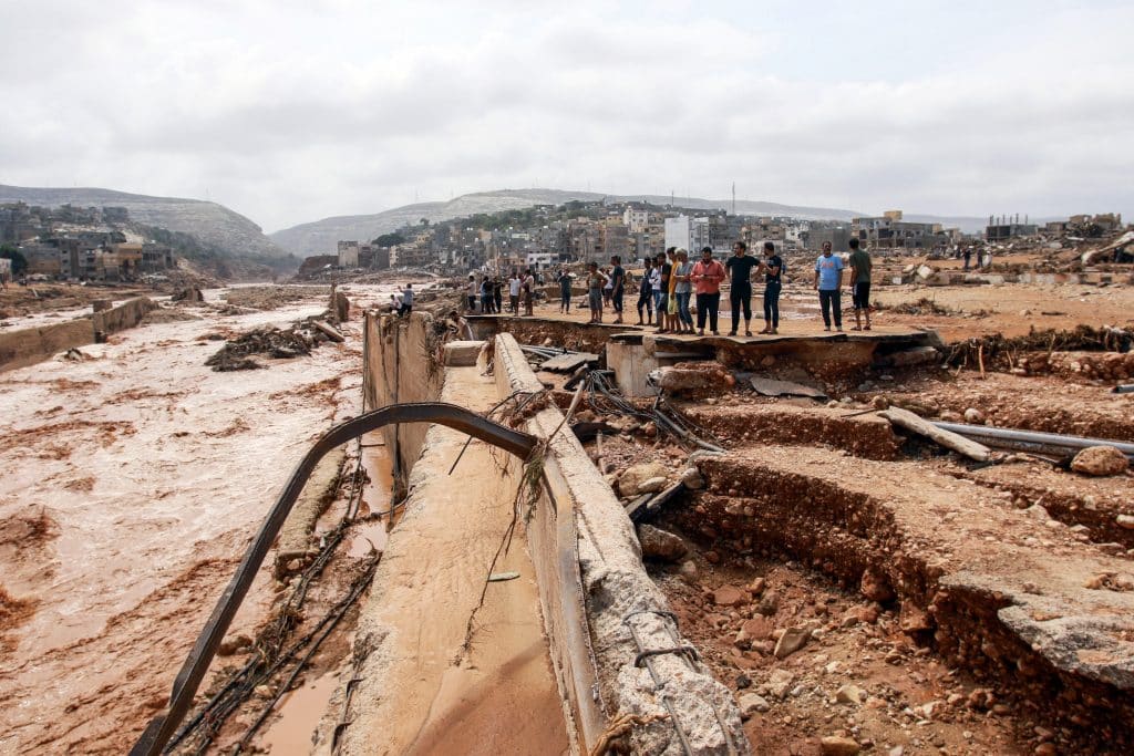 Des habitants observent les dégâts causés par les inondations à Derna dans l'est de la Libye, le 11 septembre 2023. Les fortes pluies et les coulées de boue dans la zone côtière de l'est de la Libye ont causé la mort de plus de 5 000 personnes. © UNICEF/UNI434931/AFP