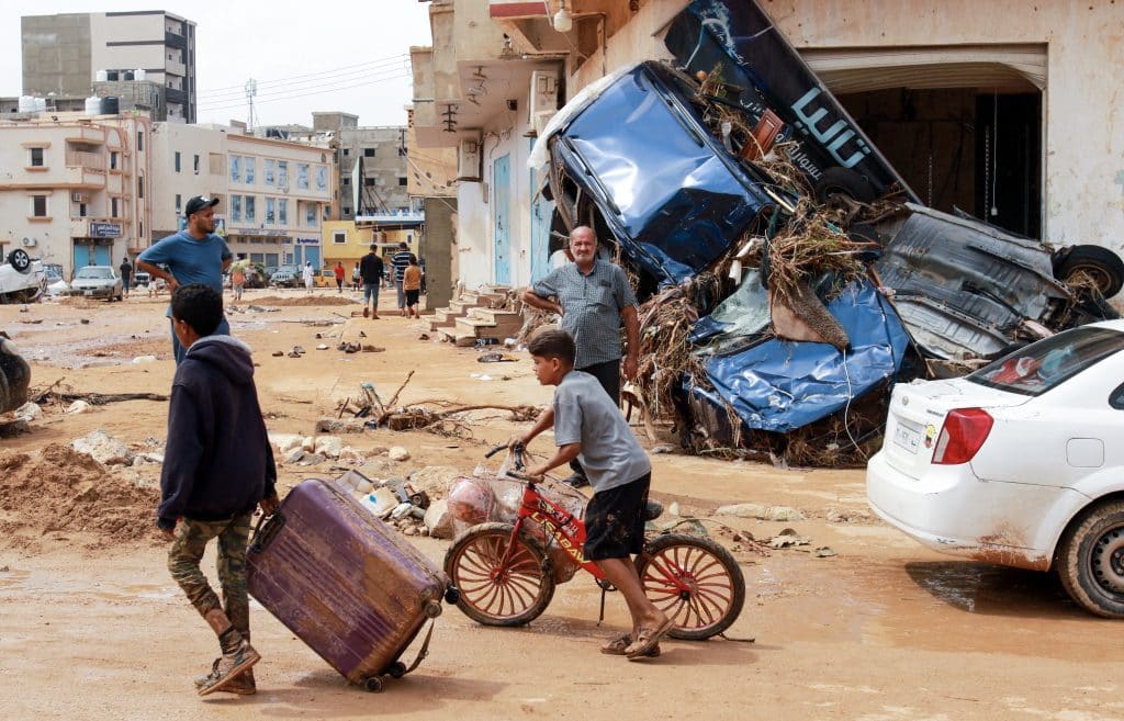 Un garçon marche devant des débris dans une zone endommagée par une crue soudaine à Derna, dans l'est de la Libye, le 11 septembre 2023. © UNICEF/UNI434932/AFP