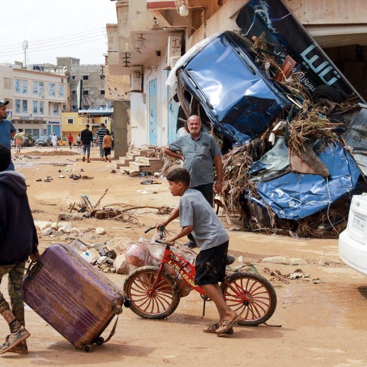 Un garçon marche devant des débris dans une zone endommagée par une crue soudaine à Derna, dans l'est de la Libye, le 11 septembre 2023. © UNICEF/UNI434932/AFP