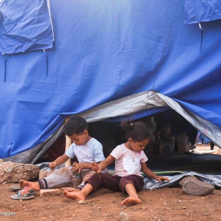 Le 12 septembre 2023, à Asni, au Maroc, des enfants jouent devant l'une des tentes fournies par le gouvernement dans un camp pour les familles qui ont perdu leur maison lors du violent tremblement de terre qui a secoué le pays le 8 septembre 2023. © UNICEF/UNI435150/Benkirane