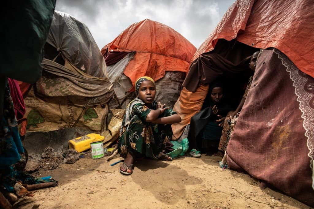 Une jeune fille est assise à l'extérieur de la tente dans laquelle vit sa famille dans un camp de personnes déplacées à Mogadiscio, en Somalie, en octobre 2022. © UNICEF/UN0742088/Condren