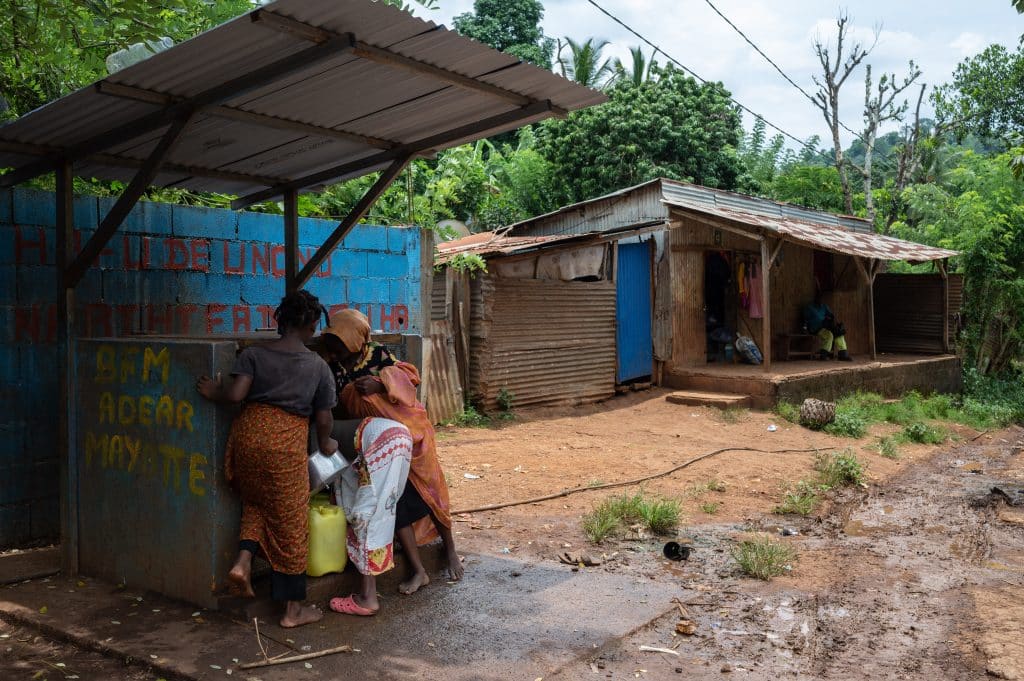 Des habitants et des enfants viennent chercher de l'eau potable avec des jerrycans à la borne-fontaine de Dzoumogne à Mayotte. (Photo Bastien Doudaine / Hans Lucas / Hans Lucas via AFP)