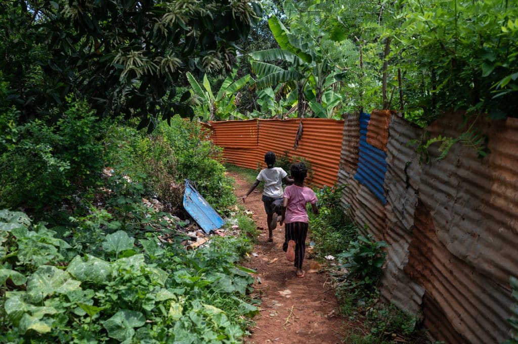 Des enfants courent dans une rue jonchée de détritus à Longoni, Mayotte. Ici, l'habitat précaire en tôle représente 39% des résidences principales recensées. En 2017, 95% des familles vivant dans ces cases ne disposaient pas d'installations sanitaires de base. (Photo Bastien Doudaine / Hans Lucas / Hans Lucas via AFP)