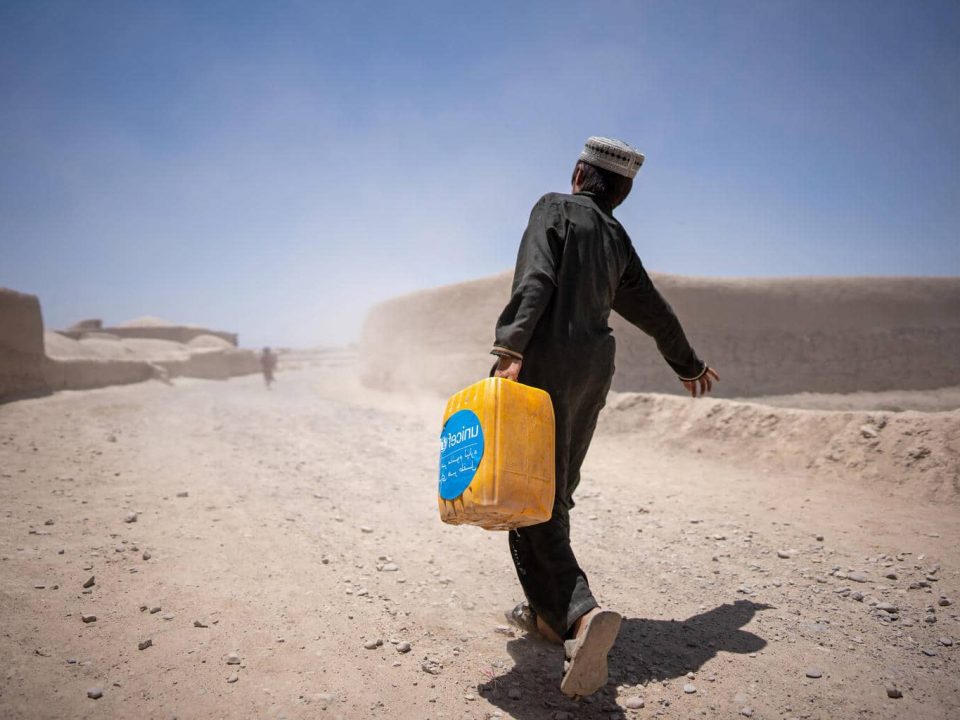 Un garçon ramène chez lui un jerrycan rempli d'eau, recueillie à un point d'eau soutenu par l'UNICEF dans le village de Noorkhail, district de Muqur, dans la province de Badghis, en Afghanistan, en juin 2023. ©UNICEF/UN0855414/Naftalin