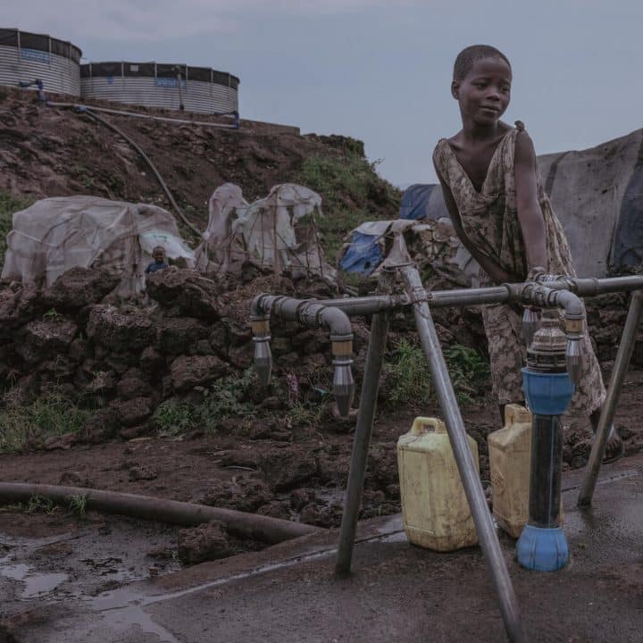 Des personnes déplacées puisent de l'eau à un point de distribution mis en place par l'UNICEF et ses partenaires dans le camp de Bulengo, à l'ouest de la ville de Goma, en République démocratique du Congo, le 21 juillet 2023. ©UNICEF/UNI418275/Ndebo