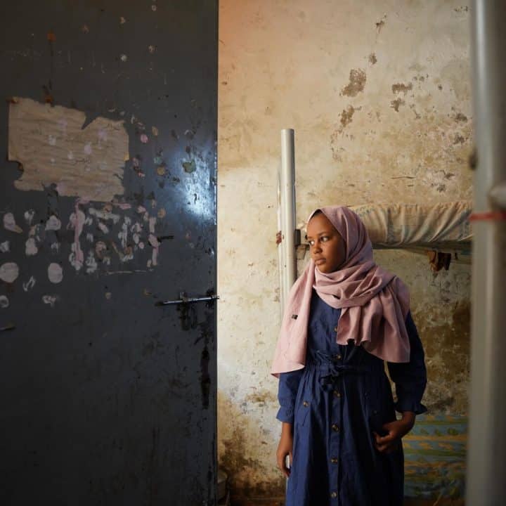Malaz, 14 ans, se tient à la fenêtre du dortoir dans le refuge temporaire pour personnes déplacées où elle réside avec sa famille. ©UNICEF/UNI427295/Awad