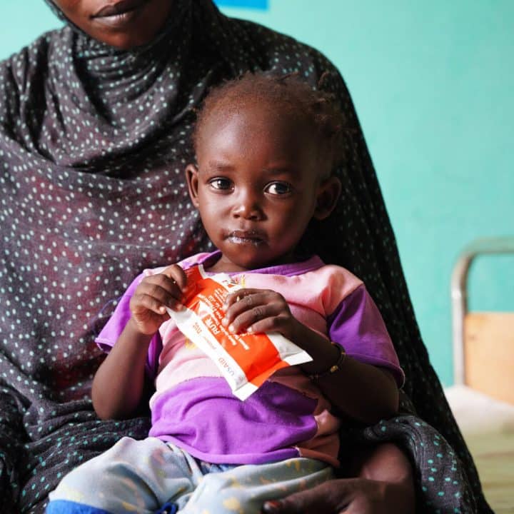 Maub, âgée d'un an, consomme un aliment thérapeutique prêt à l'emploi (RUTF) au centre de santé d'Abu Sunun, où elle est soignée pour malnutrition. ©UNICEF/UNI443662/Awad
