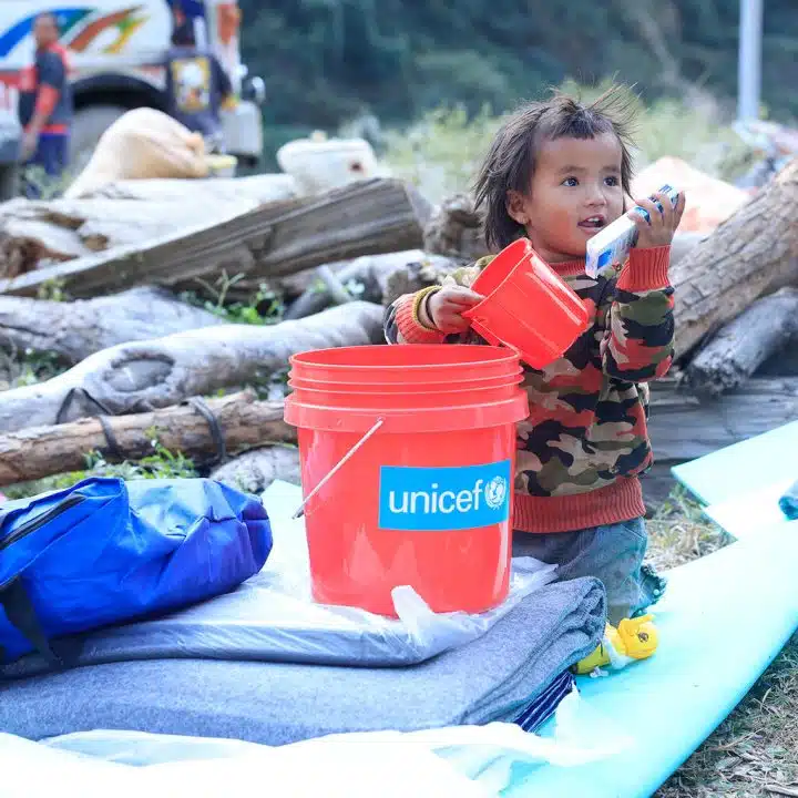 Le 6 novembre 2023, dans la municipalité d'Aathbiskot, dans le district de Rukum West - l'une des communautés les plus touchées par le séisme de magnitude 6,4 qui a frappé l'ouest du Népal le 3 novembre - un enfant joue avec des fournitures de secours distribuées par le personnel de l'UNICEF en coordination avec les autorités locales. ©UNICEF/UNI465094/Prasad Ngakhusi