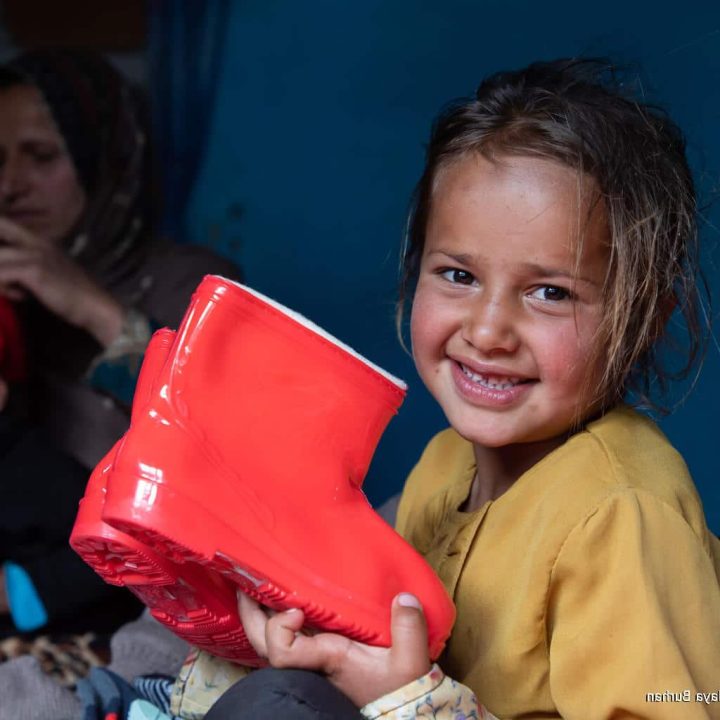 Le 14 mars 2023, Sahar, 6 ans, tient une nouvelle paire de bottes provenant d'un kit de vêtements d'hiver fourni par l'UNICEF dans la province de Panjshir, en Afghanistan. © UNICEF/UN0804431/Haya Burhan