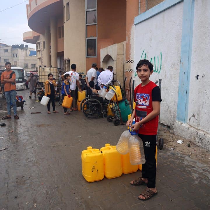Ahmad, 14 ans, pose pour une photo alors qu'il attend à la ligne d'eau potable dans la ville de Rafah. Ahmad a évacué sa maison à Jabalia il y a 17 jours pour se mettre à l'abri des bombardements. © UNICEF/UNI463721/El Baba