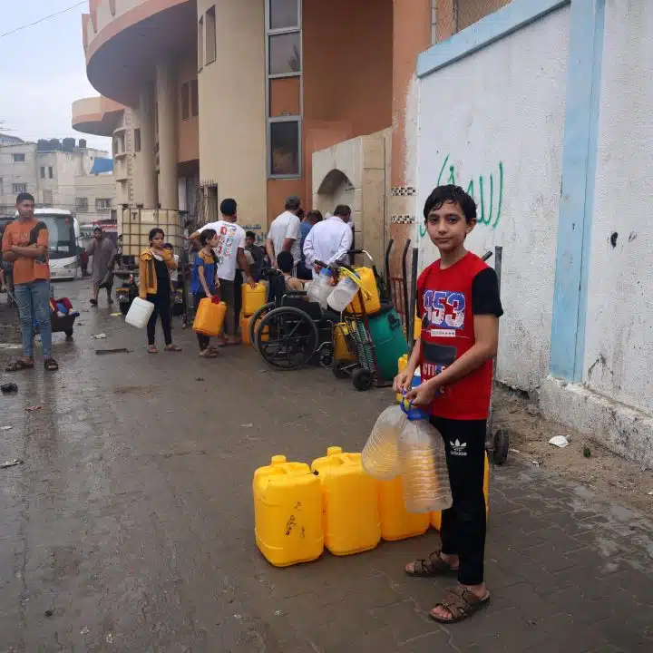 Ahmad, 14 ans, pose pour une photo alors qu'il attend à la ligne d'eau potable dans la ville de Rafah. Ahmad a évacué sa maison à Jabalia il y a 17 jours pour se mettre à l'abri des bombardements. © UNICEF/UNI463721/El Baba