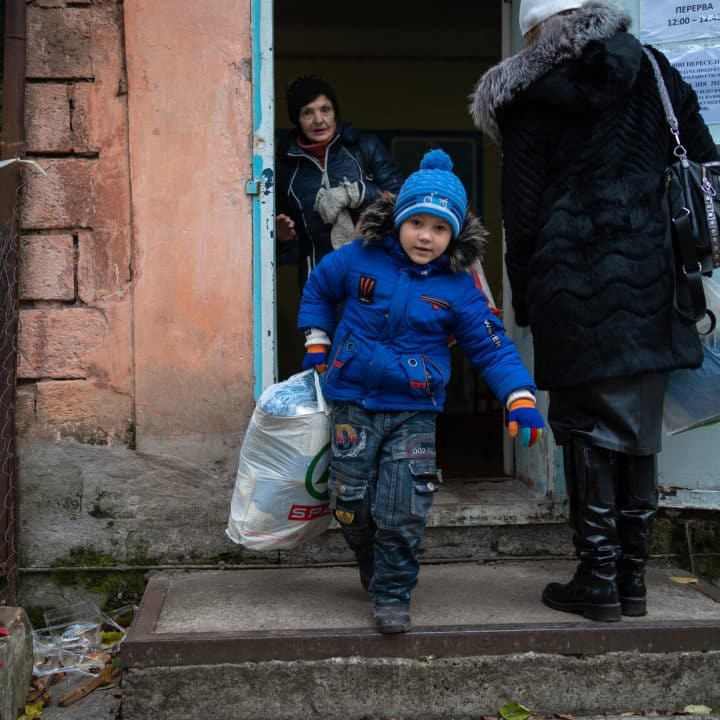 Une famille reçoit des kits de vêtements d'hiver pour les enfants et d'autres fournitures de l'UNICEF dans la communauté de Marhanets, région de Dnipropetrovsk, Ukraine, le 23 novembre 2023. ©UNICEF/UNI478866/Filippov