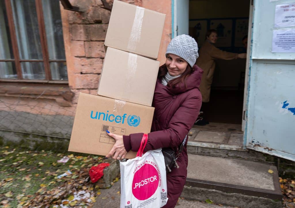 Le 23 novembre 2023, cette femme reçoit un kit contenant des vêtements chauds et d'autres fournitures d'hiver. © UNICEF/UNI478867/Filippov