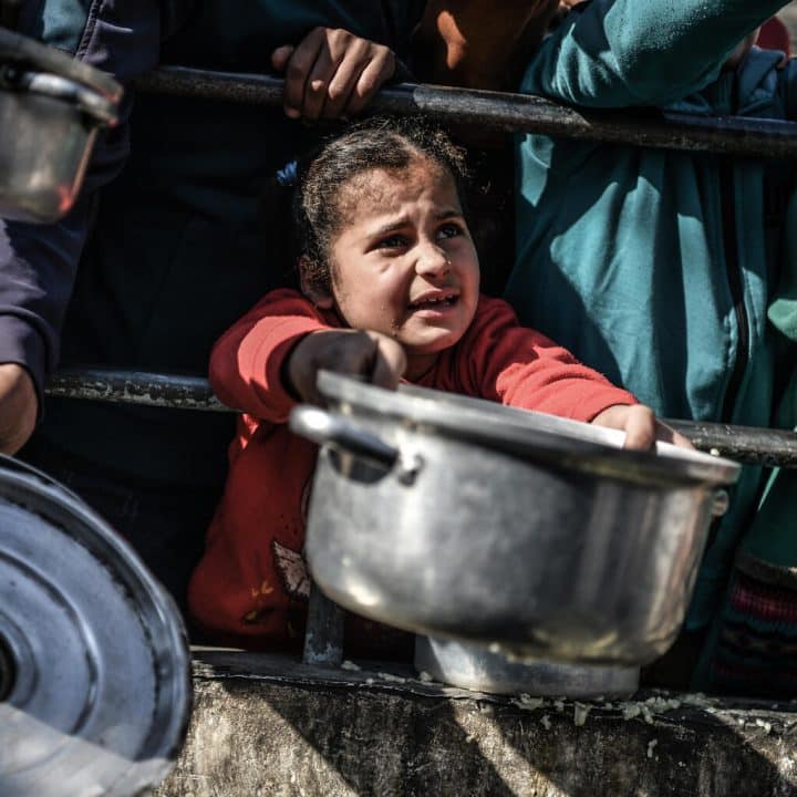 Shaima, 8 ans, attend son tour dans la foule pour recevoir un repas d'un centre caritatif qui distribue de la nourriture gratuitement dans la ville de Rafah, au sud de la bande de Gaza. © UNICEF/UNI495568/ZAGOUT