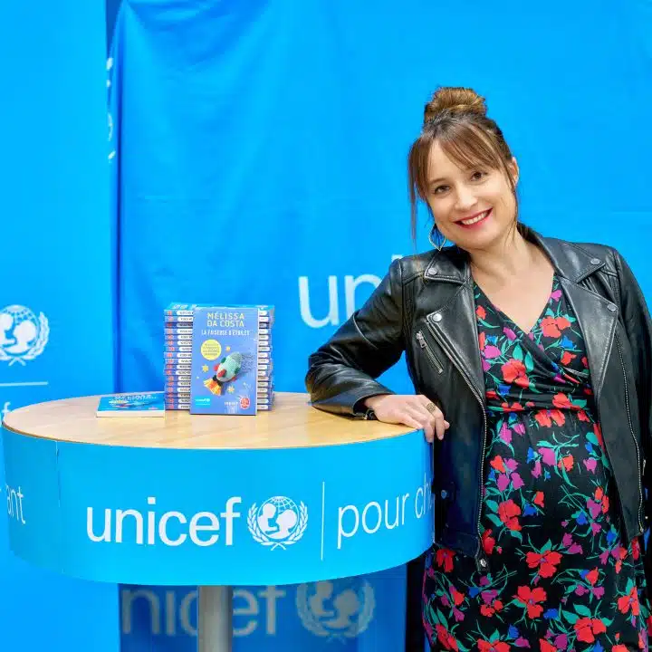 Mélissa Da Costa pose aux côtés de son roman "La faiseuse d'étoiles" dont une partie des bénéfices ont permis de collecter 400 000 euros au profit des actions de l'UNICEF. © Cyrille George Jerusalmi/UNICEF France