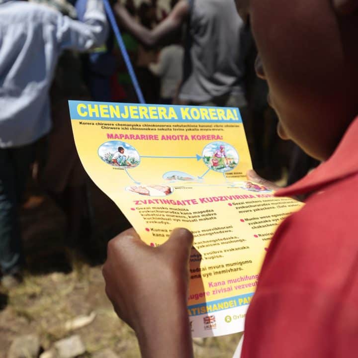 Des brochures de sensibilisation au choléra sont distribuées aux personnes rassemblées au Skyline Junction à Chimanimani, au Zimbabwe. ©UNICEF/UN0295694