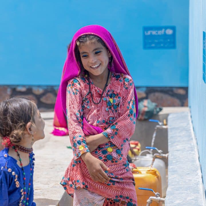 Le 25 juillet 2023, des enfants recueillent de l'eau potable grâce à un robinet installé par l'UNICEF dans la province de Badghis, en Afghanistan.© UNICEF/UNI418633/Bidel