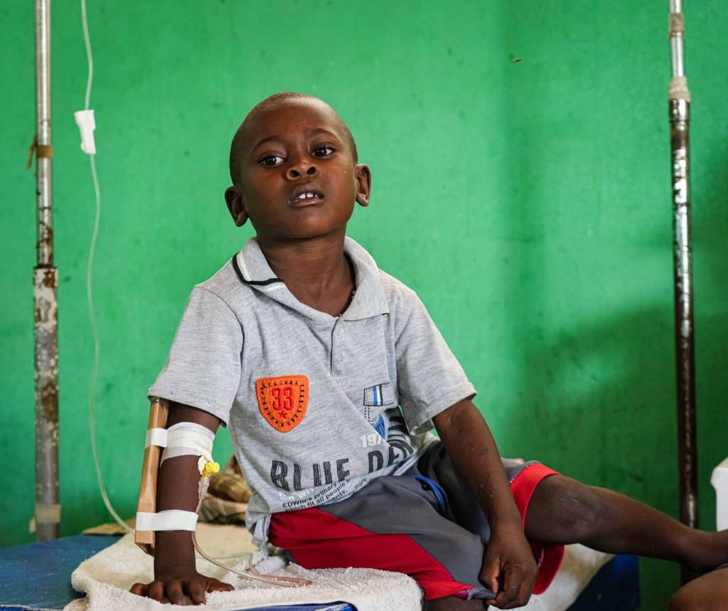 Un jeune enfant souffrant du choléra est assis sur son lit au centre de santé de Saint Michel de l'Attalaye, Haïti. © UNICEF/UNI435654/Joseph