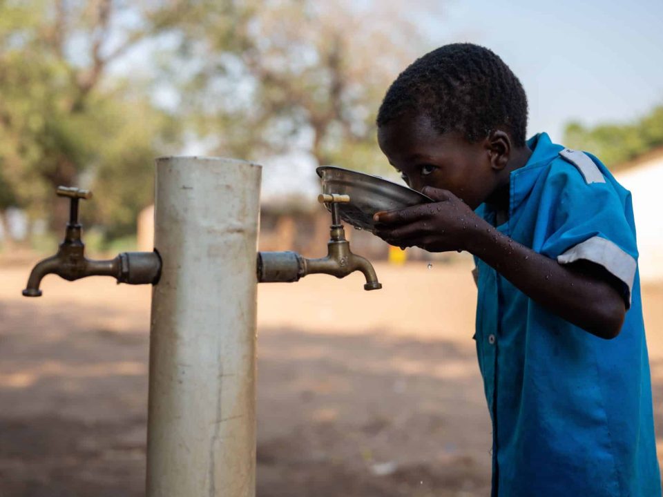 Portrait d'un élève buvant de l'eau potable grâce aux installations soutenues par l'UNICEF. Dans la région de Kalima, au Malawi, l'accès à l'eau potable est un défi. Entre 2022 et 2023, le pays a été frappé de plein fouet par la pire épidémie de choléra depuis 20 ans. Près de 60 000 personnes ont été touchées © UNICEF/UNI466232/Khanyizira