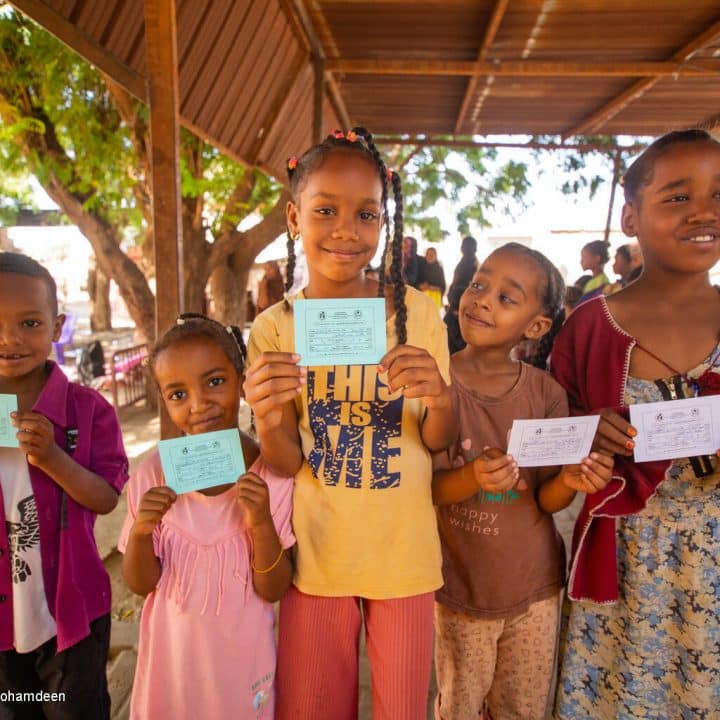 Le 21 novembre 2023, des enfants montrent leur carte de vaccination après avoir reçu des doses de vaccin contre le choléra lors d'une campagne de vaccination dans l'État de Madani Gezira. © UNICEF/UNI476505/Mohamdeen